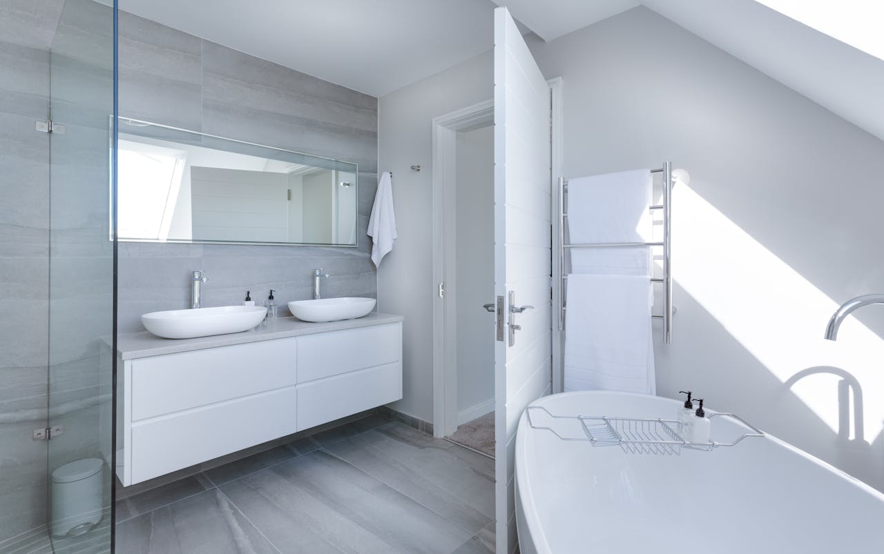 about-us-01 Sleek contemporary bathroom with bathtub and twin sinks, showcasing minimalist design and luxury.